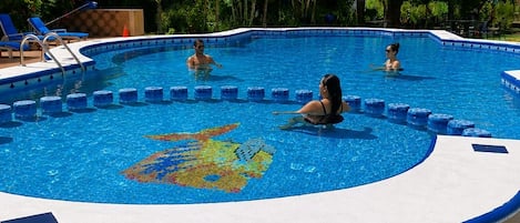 Una piscina con borde de azulejos y un diseño decorativo en el centro.