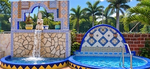 A pool area with a fountain, tiled walls, and a statue. - Cúpulas Blue Wellness Residence (Cozumel)