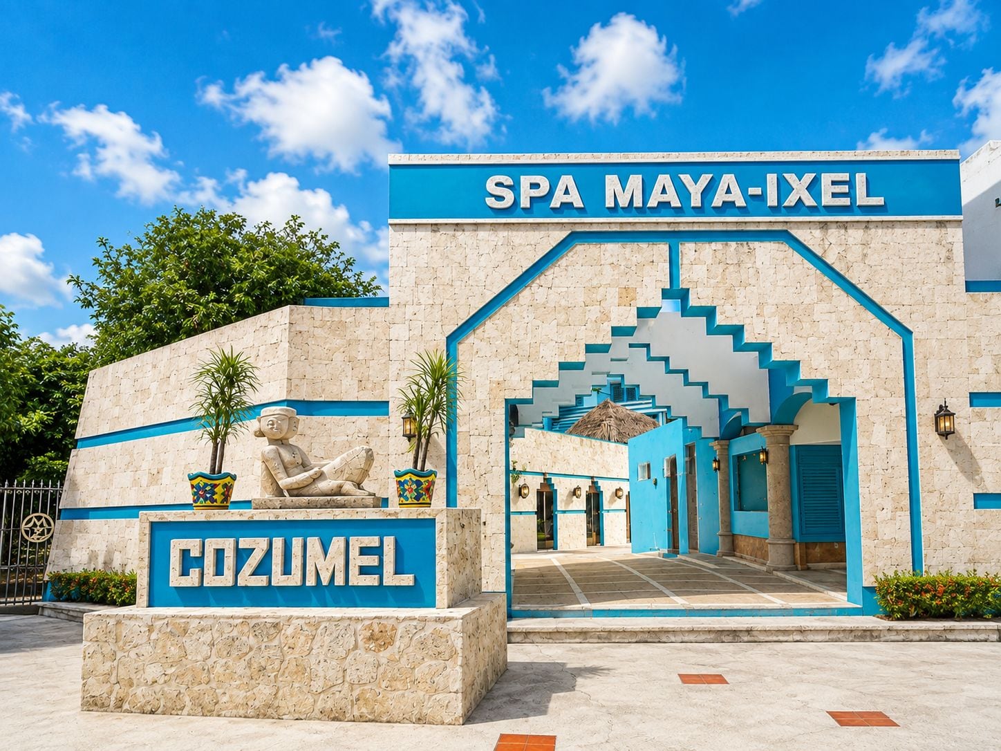 Indgangen til SPA MAYA-IXEL med en stenfacade og en blå bue.
