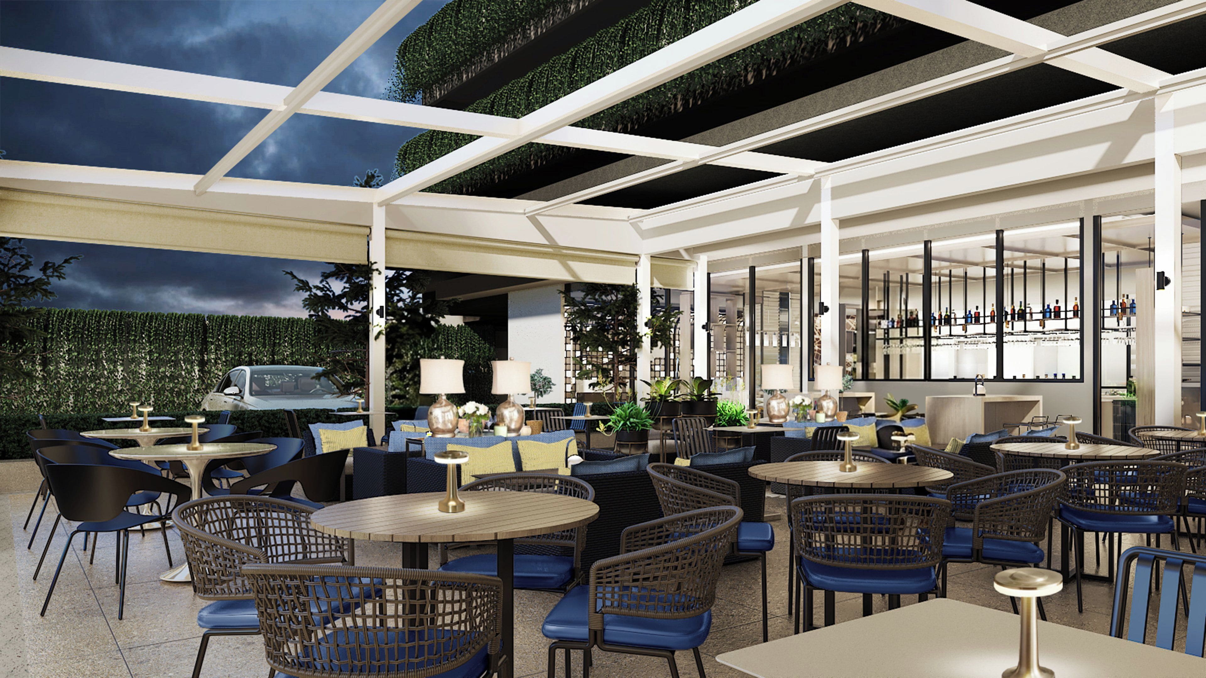 An outdoor seating area with round tables and wicker chairs, a bar area with a mirrored wall, and a view of a car in the background.