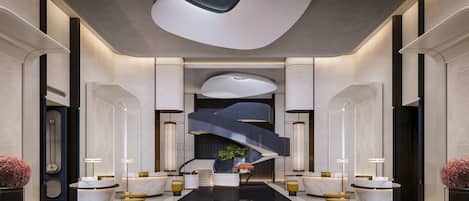 A modern lobby with a central staircase, marble reception desk, and symmetrical design.