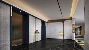 A modern hallway with marble flooring, a star on the wall, and a phone on a shelf. - Voco Chengdu Movie Metropolis By Ihg (Chengdu)