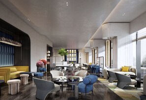 Un hall d’hôtel moderne, doté de différents types de sièges, d’une grande fenêtre et d’une plante d’ornement placée au centre.