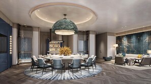 A modern dining area with a round table, chairs, a decorative centerpiece, and a large hanging light fixture. - Voco Chengdu Movie Metropolis By Ihg (Chengdu)