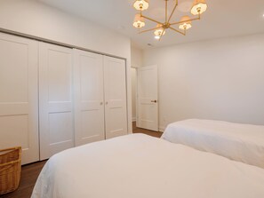 A bedroom with two beds, a wardrobe, and a chandelier. - Pecan Manor Off Main - Historic Downtown Franklin (Franklin)