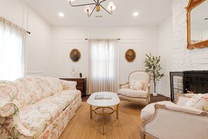 A living room with a sofa, armchair, coffee table, and a fireplace. - Pecan Manor Off Main - Historic Downtown Franklin (Franklin)