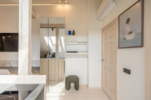 Eine moderne Küche mit einem großen Fenster, einem eingebauten Backofen und einer weißen Arbeitsplatte.