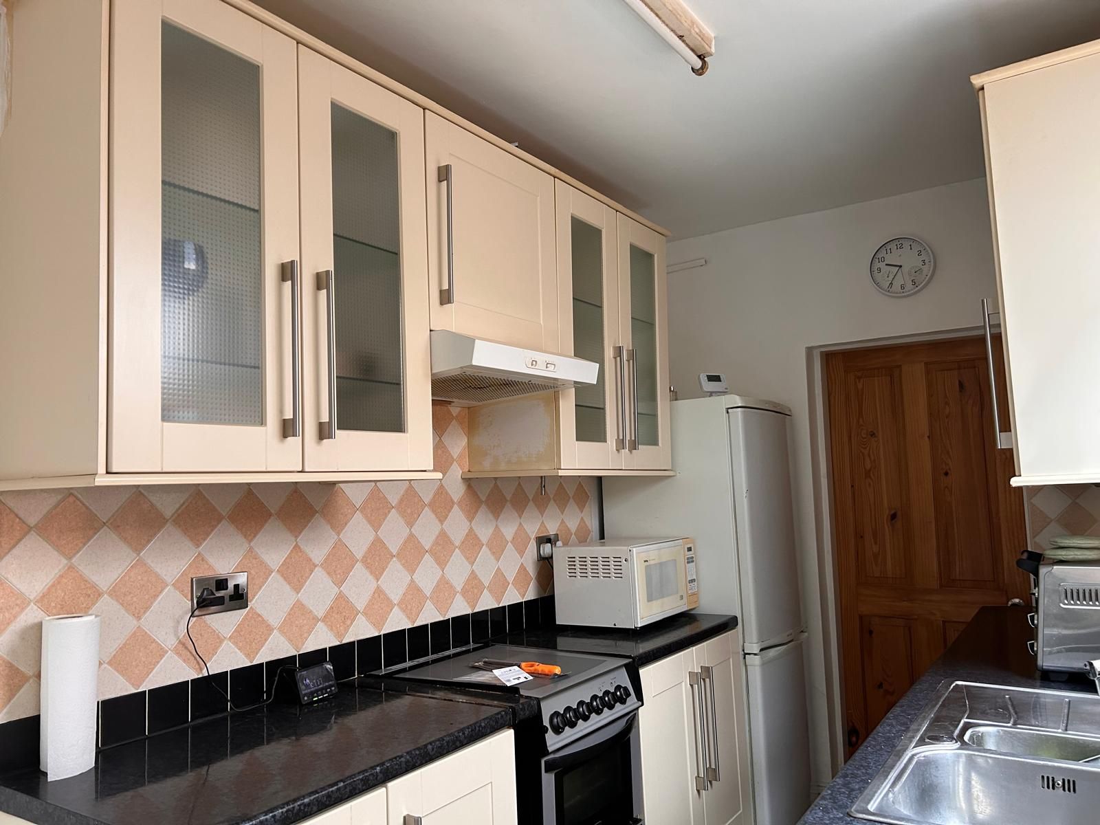 A kitchen with a microwave, stove, and refrigerator.