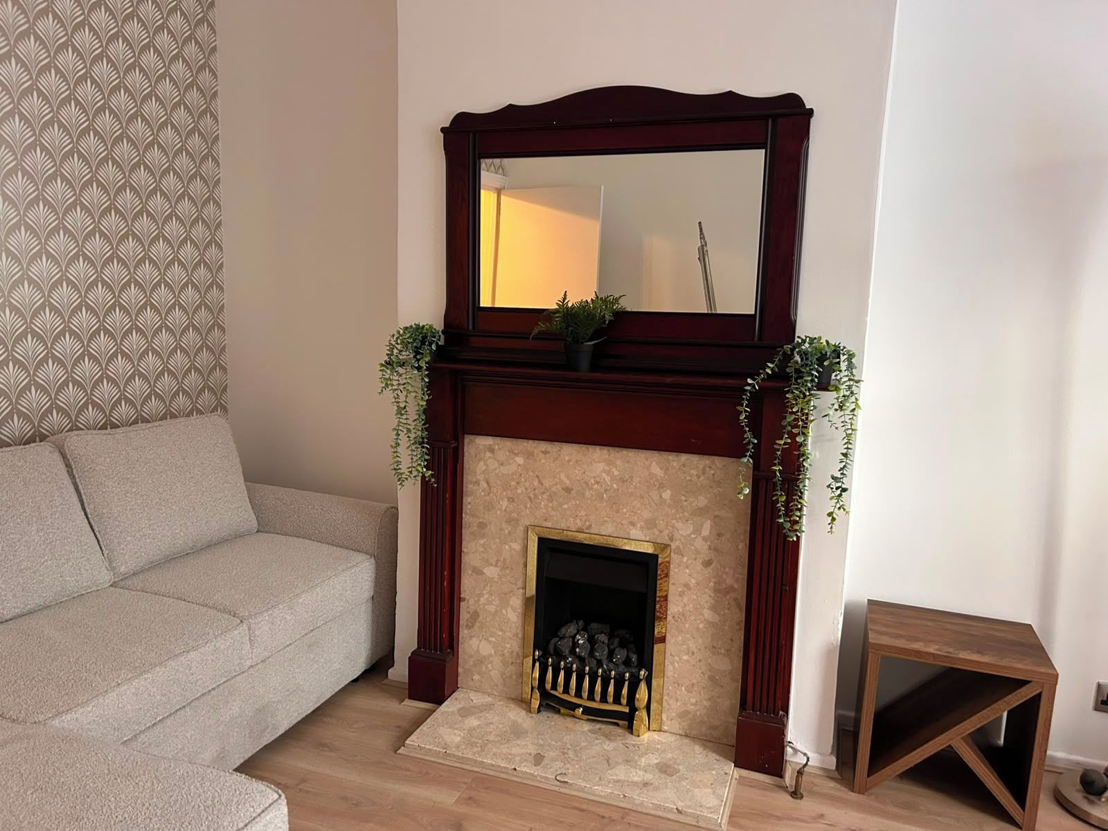 Een woonkamer met een open haard, een bank en een kleine houten tafel.