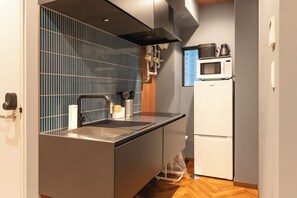 Eine kleine Küche mit Mikrowelle, Kaffeemaschine und kleinem Kühlschrank.