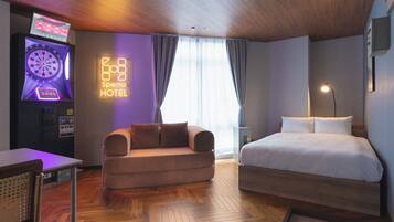 Quarto de hotel com cama, sofá, televisão e alvo de dardos.