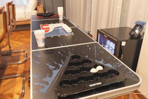 A kitchen with a black countertop, a coffee machine, and a refrigerator.