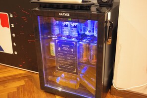 Vitrina refrigerada con indicador de temperatura digital, que contiene diversas bebidas, incluyendo cerveza Asahi y otras gaseosas.