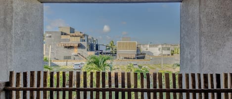 A view from a balcony with a concrete ceiling and wooden railing.