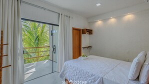 A bedroom with a bed, a door, a window with curtains, and a view of palm trees. - House w 3 Suites n Pool 100m From the sea Hva0009 (Passo de Camaragibe)
