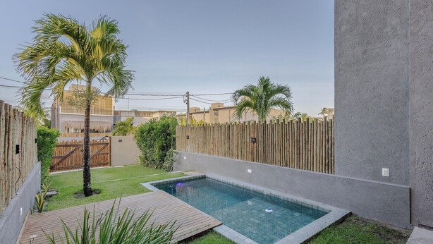 A residential area with a swimming pool, palm trees, and a wooden fence. - House w 3 Suites n Pool 100m From the sea Hva0009 (Passo de Camaragibe)