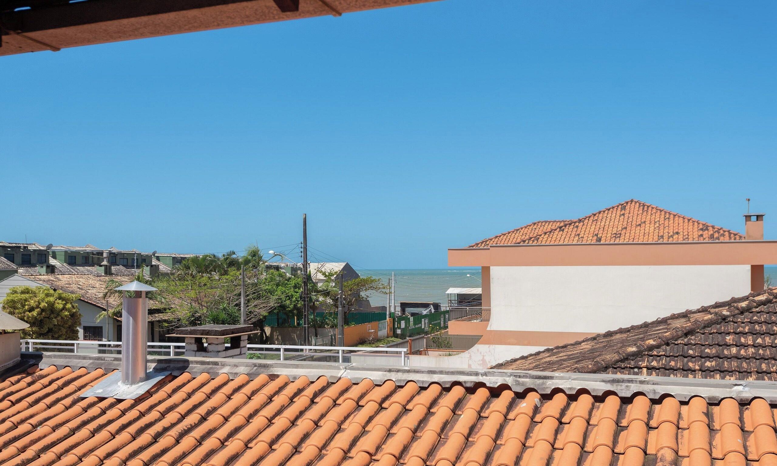 Un bâtiment situé sur la côte, doté d’un toit en tuiles, offrant une vue dégagée sur la mer et disposant d’un jardin clos.