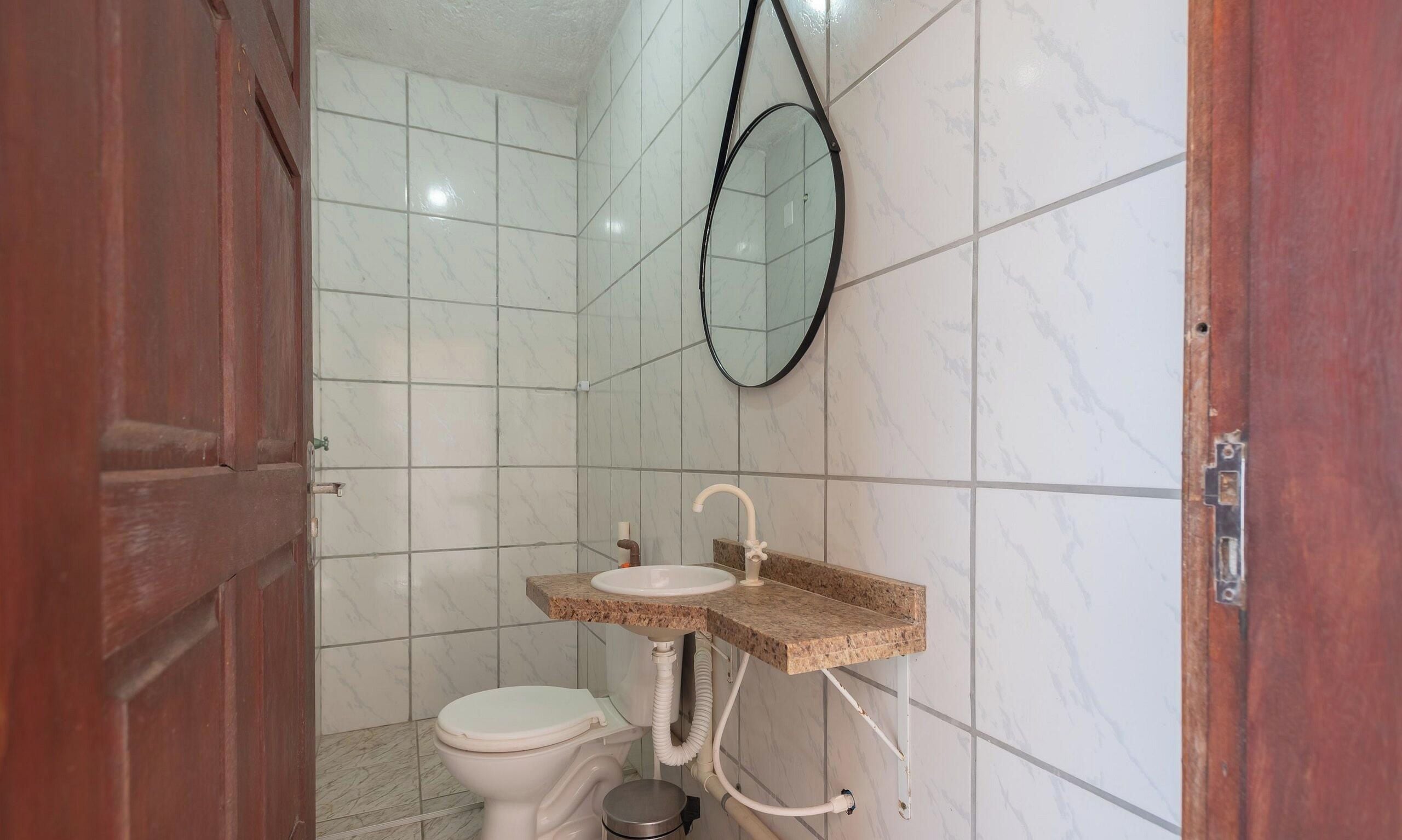Un baño con inodoro, lavabo y espejo.