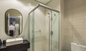 A modern bathroom with a glass-enclosed shower, a round mirror, and a white sink. - Modern Apartment Facing Praca das Etnias Cbg0306 (Gramado)