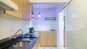 Una cucina moderna con piano di lavoro nero, lavello in acciaio inossidabile e pensili in legno.
