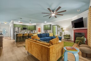 Un salon moderne avec un canapé, un téléviseur et une cheminée.