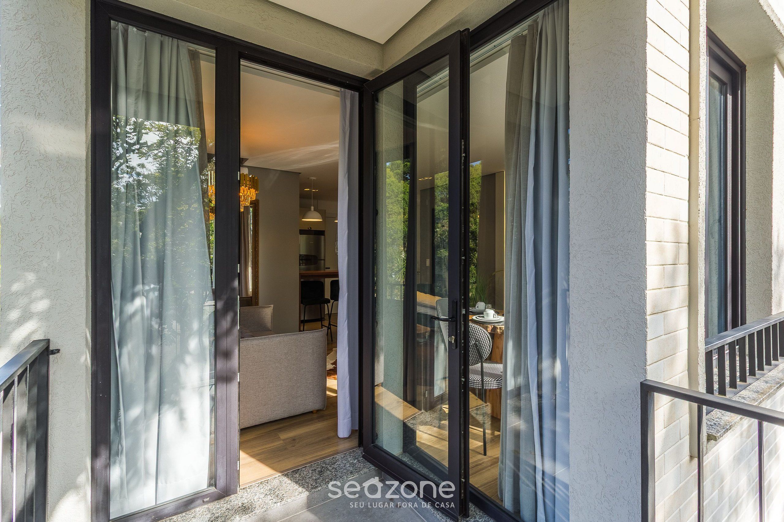 Un interior moderno con una puerta de cristal que da a un balcón.