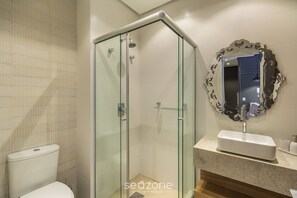 A modern bathroom with a glass-enclosed shower, a white sink, and a decorative mirror with an ornate frame. - Charming 1-bedroom Ap in Gramado Cbg0305 (Gramado)