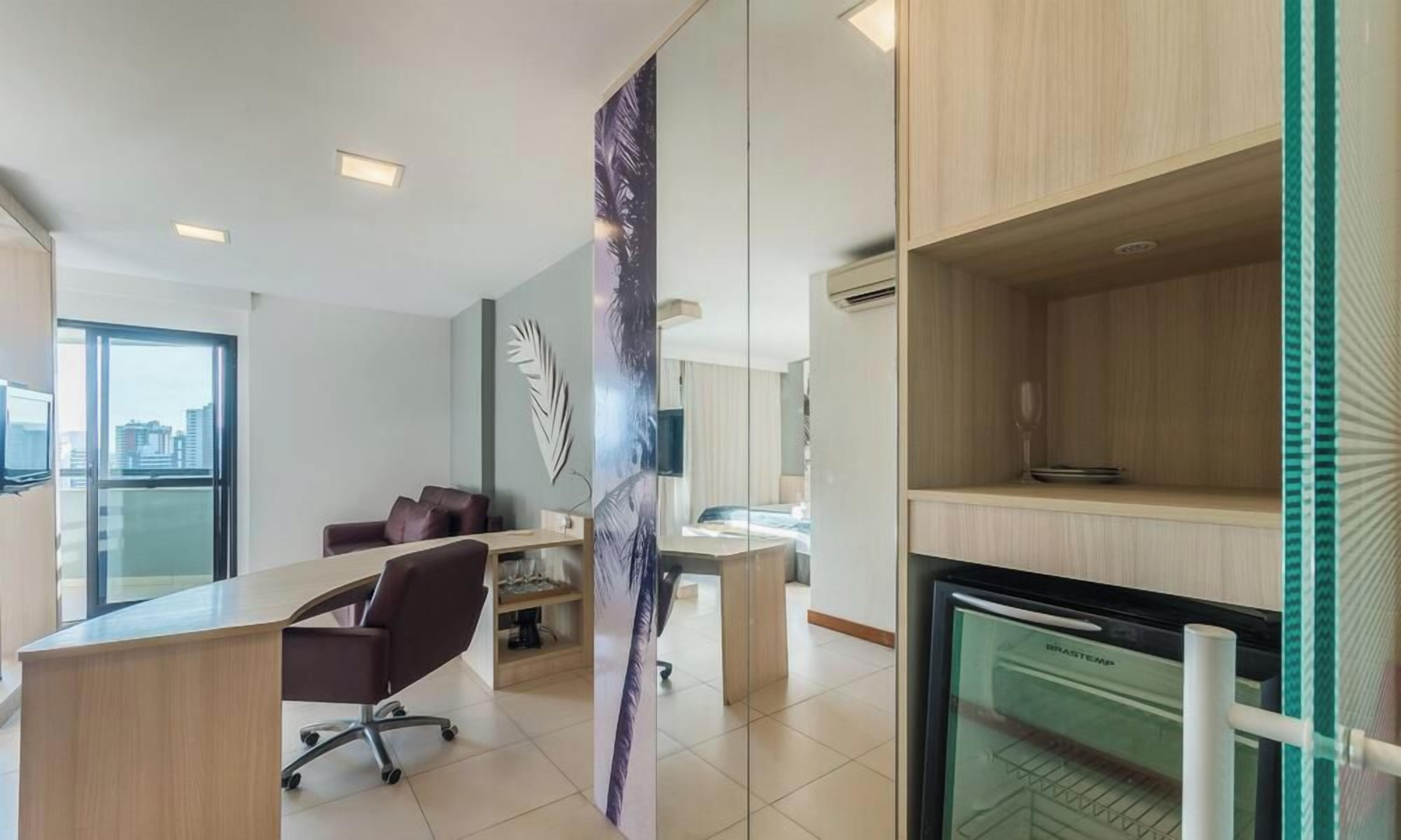 Un espace de bureau moderne comprenant un bureau, un fauteuil de bureau et une grande fenêtre.