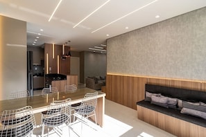 Una cocina moderna con comedor, que cuenta con una encimera larga y taburetes de bar.