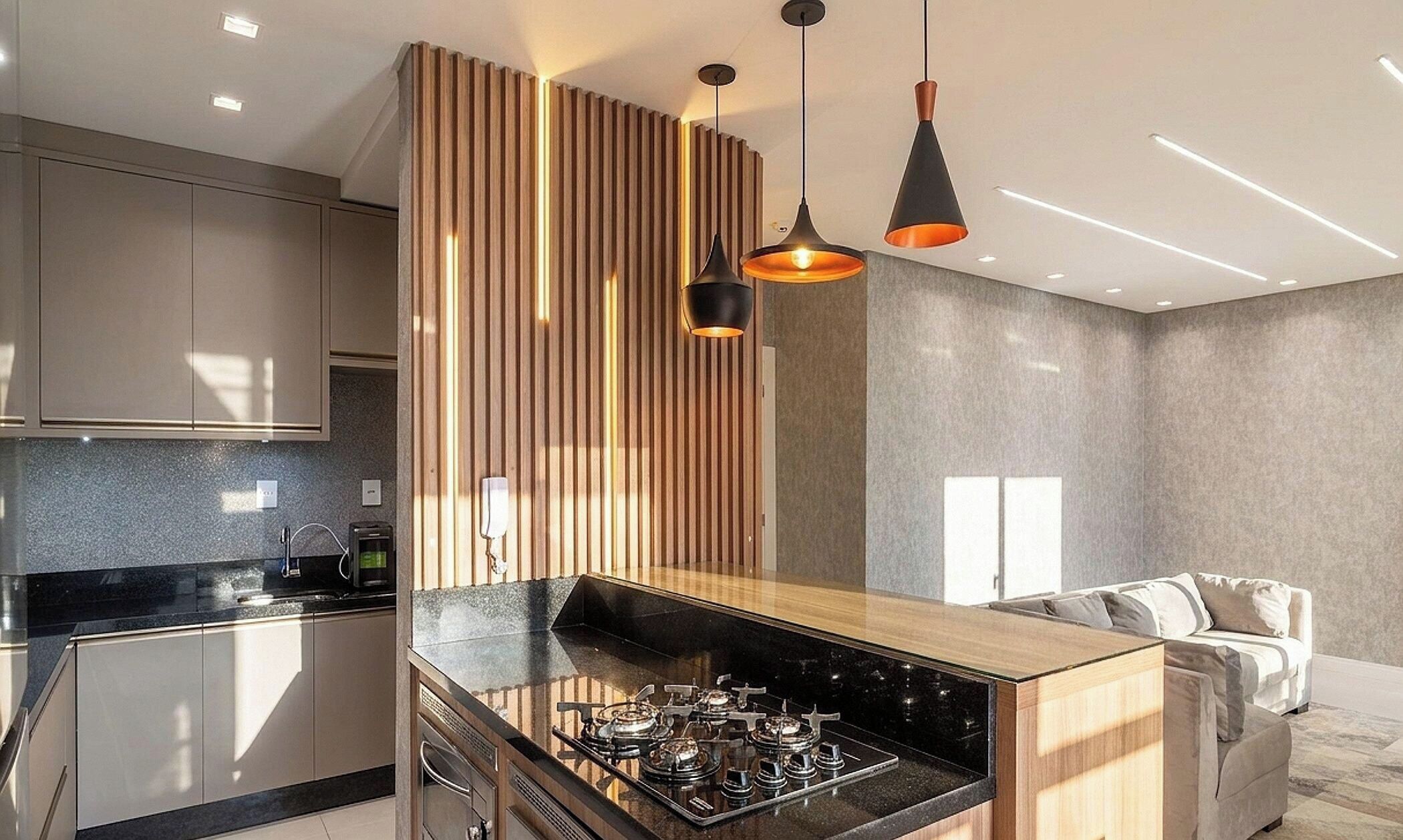 A modern kitchen with a central island, stainless steel appliances, and pendant lighting.