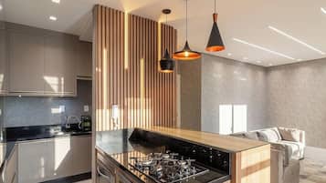 A modern kitchen with a central island, stainless steel appliances, and pendant lighting.