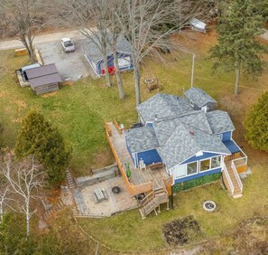 A residential property with a main house, a detached garage, and a small shed.