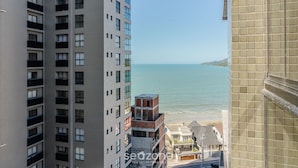 A high-rise building with multiple balconies overlooking a beach. - Apt w/ Private BBQ 90m From the Sea Rih0802 (Porto Belo)