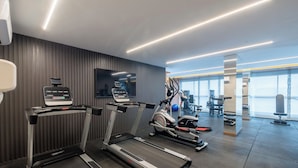 Et moderne fitnesscenter med løbebånd, crosstrainere og styrkemaskiner.