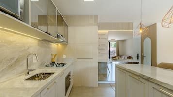 A modern kitchen with a marble countertop, stainless steel appliances, and a built-in oven.