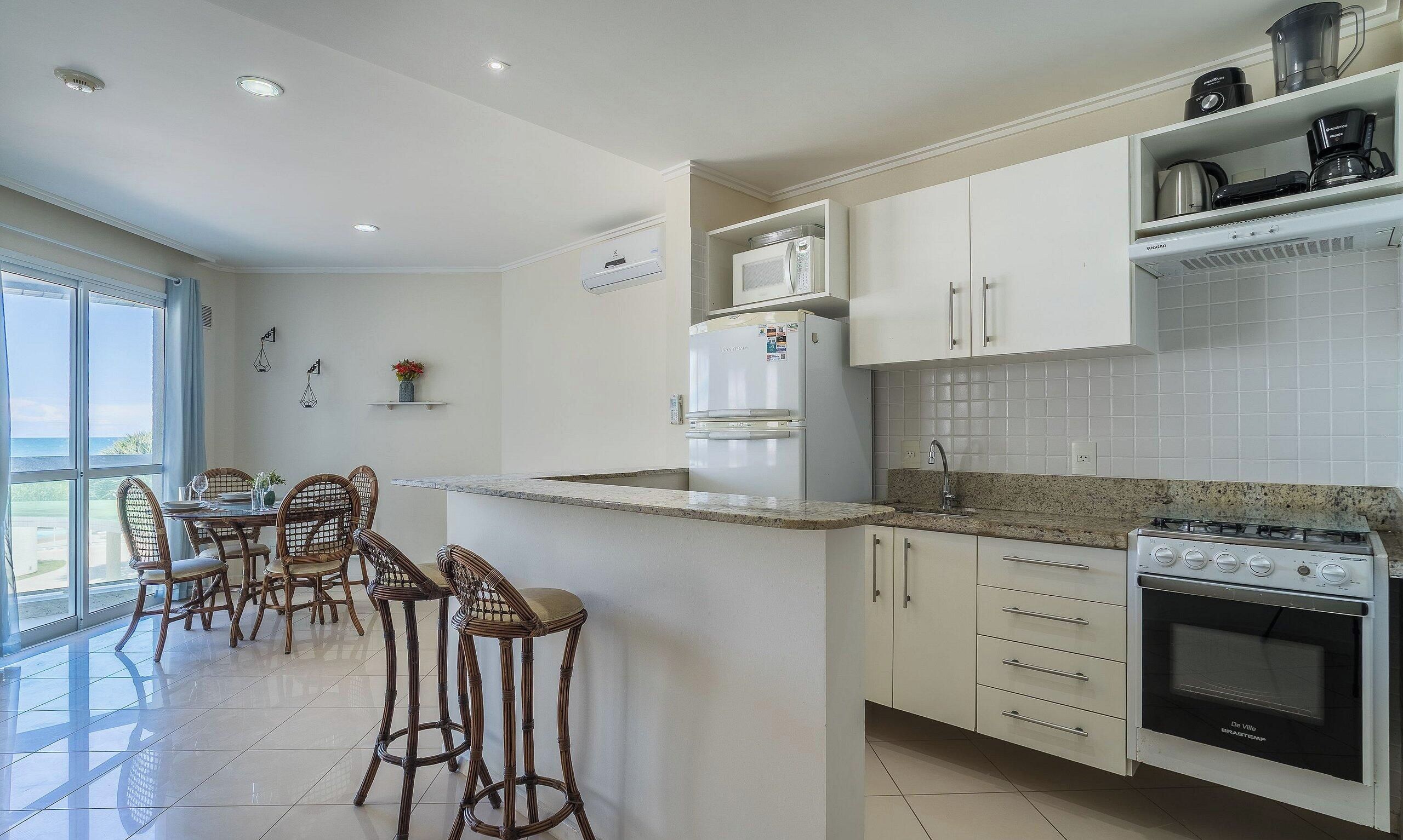 Une cuisine moderne dotée d’un îlot central, de meubles blancs et d’une cuisinière De Ville.
