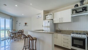 A modern kitchen with a central island, white cabinetry, and a De Ville stove.