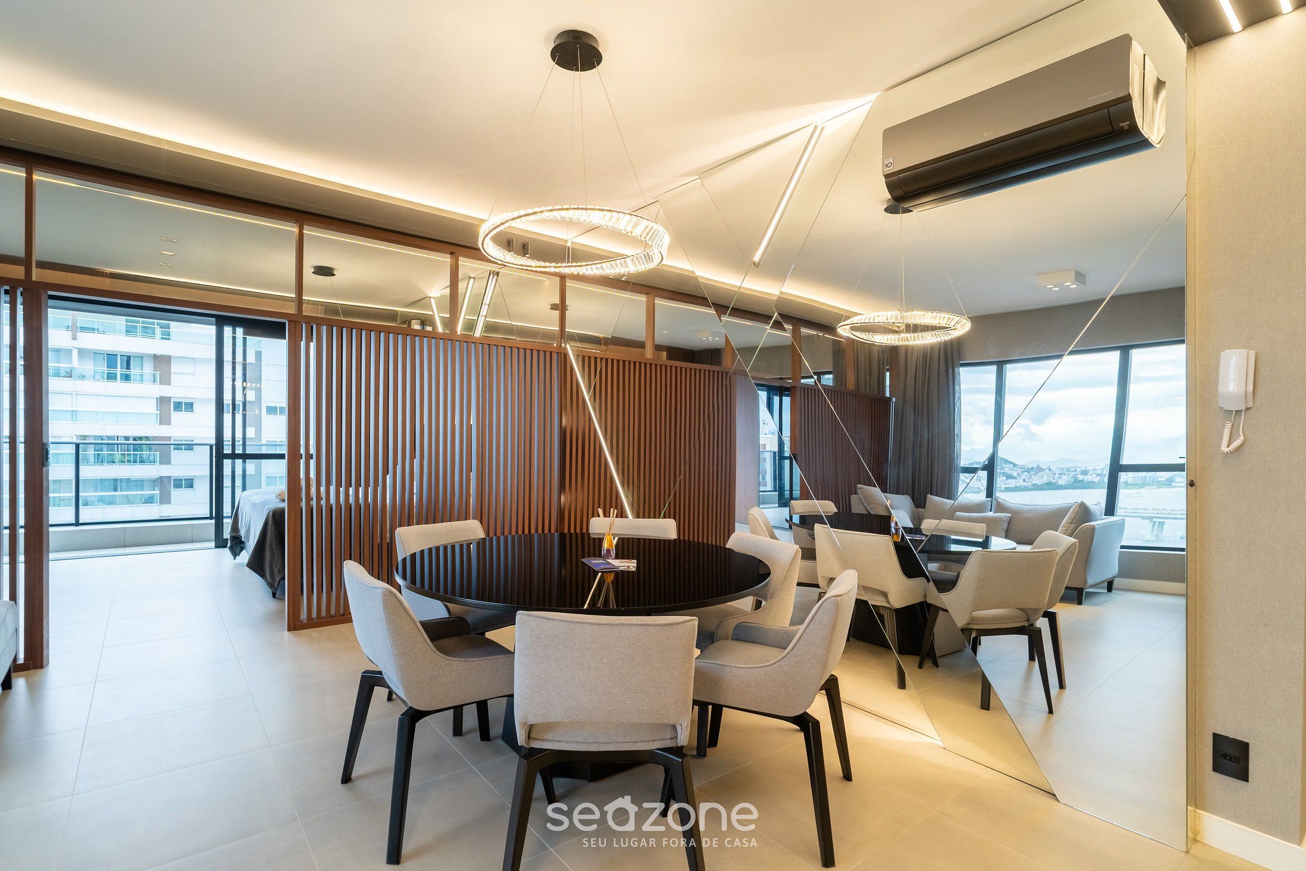 A modern dining area with a round table, chairs, and pendant lighting.