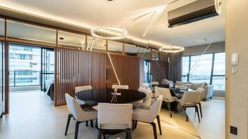 A modern dining area with a round table, chairs, and pendant lighting.