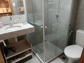 A modern bathroom with a glass-enclosed shower, a white sink with a speckled countertop, and a toilet. - Studio in Build. w/ Pool, 270m fr the sea Cao0903 (Salvador)