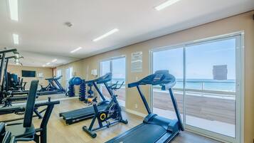 Une salle de sport équipée de tapis de course, de vélos d’exercice et d’appareils de musculation.