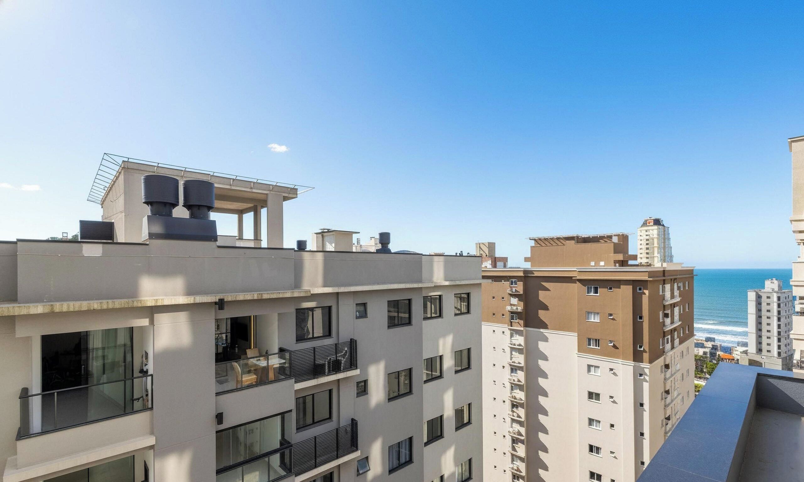 Un edificio residencial de varios pisos con balcones, ventanas amplias y vista al mar.