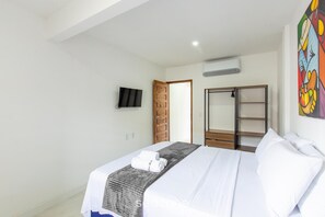 A hotel room with a bed, a TV, a wardrobe, and a painting on the wall. - Modern Apartment, 160 m From Cumbuco Beach Mcu0103 (Caucaia)