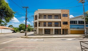A multi-story building with balconies, a stop sign, and a clear sky. - Modern Apartment, 160 m From Cumbuco Beach Mcu0103 (Caucaia)