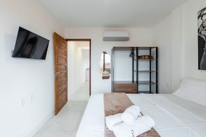 A hotel room with a bed, a television, a wardrobe, and a mirror. - Apt 1 Bedroom 160m Beach Ed Cumbuco Real Mcu0203 (Caucaia)