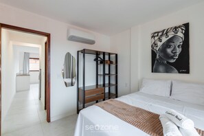 Ein Schlafzimmer mit Bett, Kleiderschrank, Spiegel und einem Bild an der Wand.