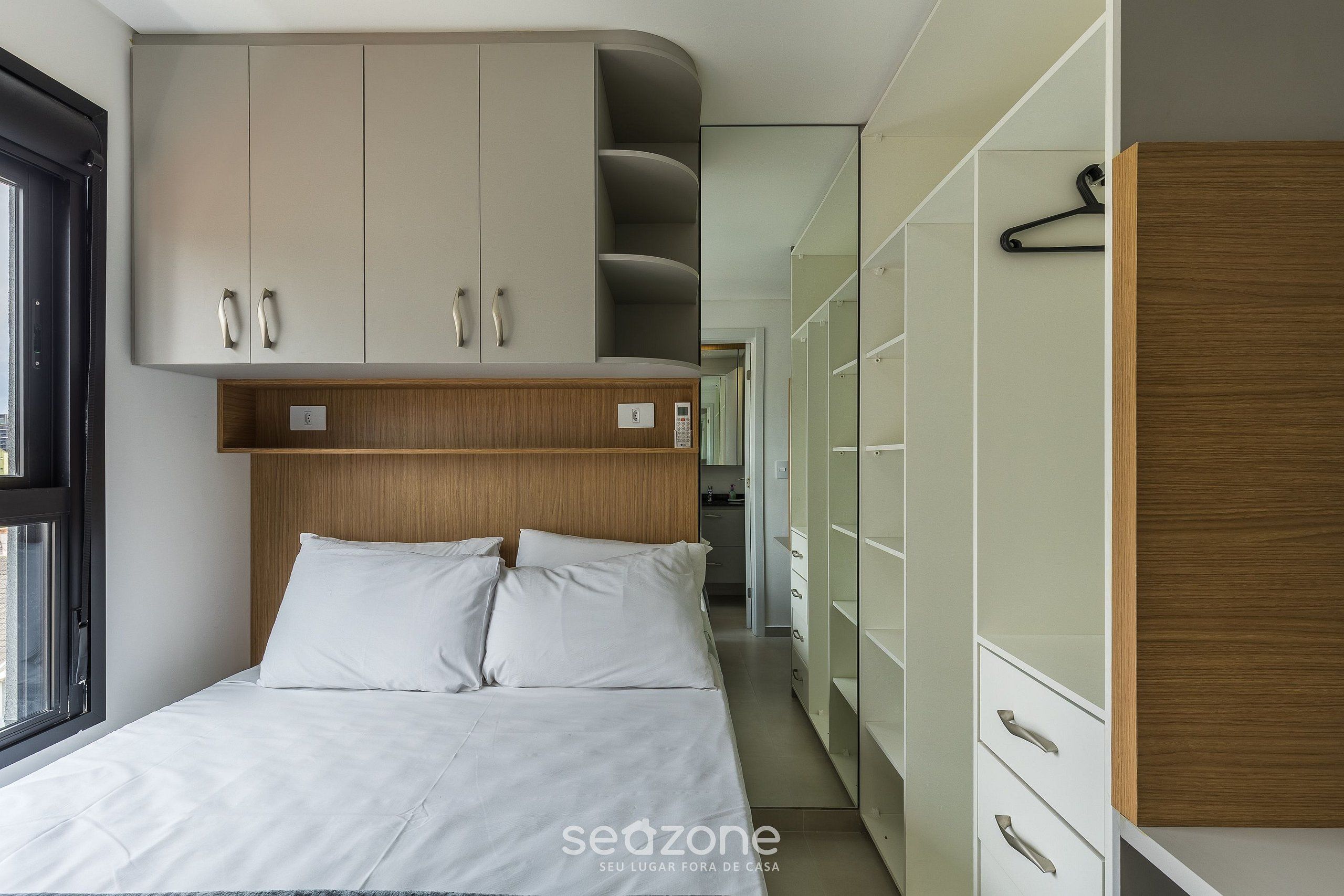 Ein Schlafzimmer mit einem Bett, einem Kleiderschrank und einem Spiegel.