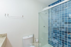 A bathroom with a glass shower enclosure, a toilet, and a towel rack. - Apt Sea View 160m Beach Ed Cumbuco Real Mcu0201 (Caucaia)