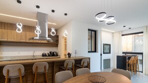 A modern kitchen with a central island, bar stools, and pendant lighting. - Apto w/ 3 En-suites, BBQ & Ocean View Rih0203 (Porto Belo)
