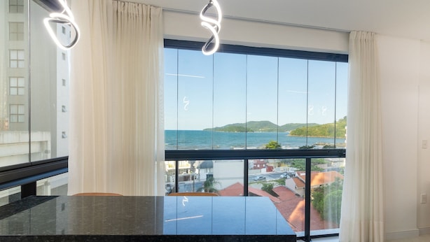 A modern room with a large window, a marble countertop, and a view of the sea. - Apto w/ 3 En-suites, BBQ & Ocean View Rih0203 (Porto Belo)